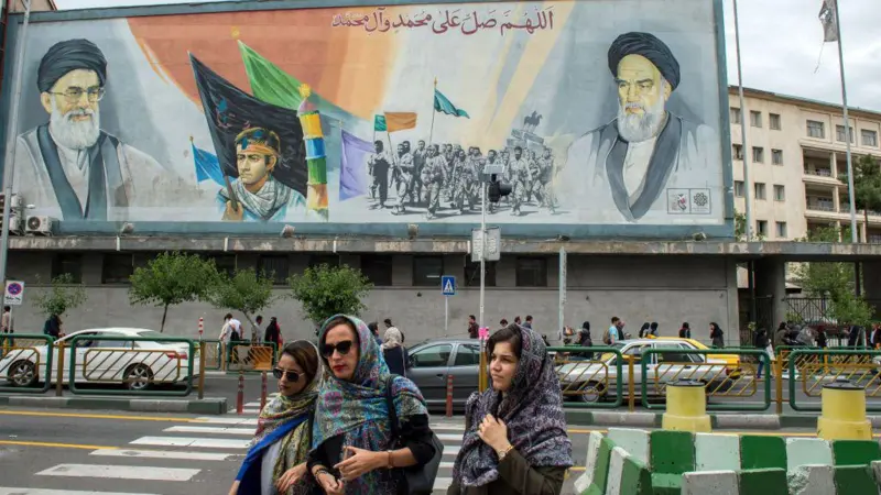 Повседневная жизнь простых иранцев протекает под сенью бесчисленных изображений Али Хаменеи, иногда в сопровождении портретов основателя Исламской республики Рухоллы Хомейни (справа)..png Повседневная жизнь простых иранцев протекает под сенью бесчисленных изображений Али Хаменеи, иногда в сопровождении портретов основателя Исламской республики Рухоллы Хомейни (справа)..png